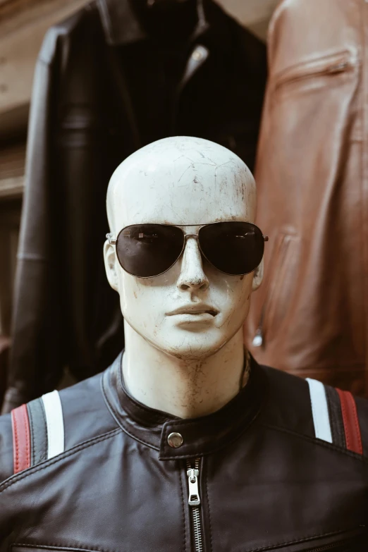 a mannequin in sunglasses and leather jacket on display