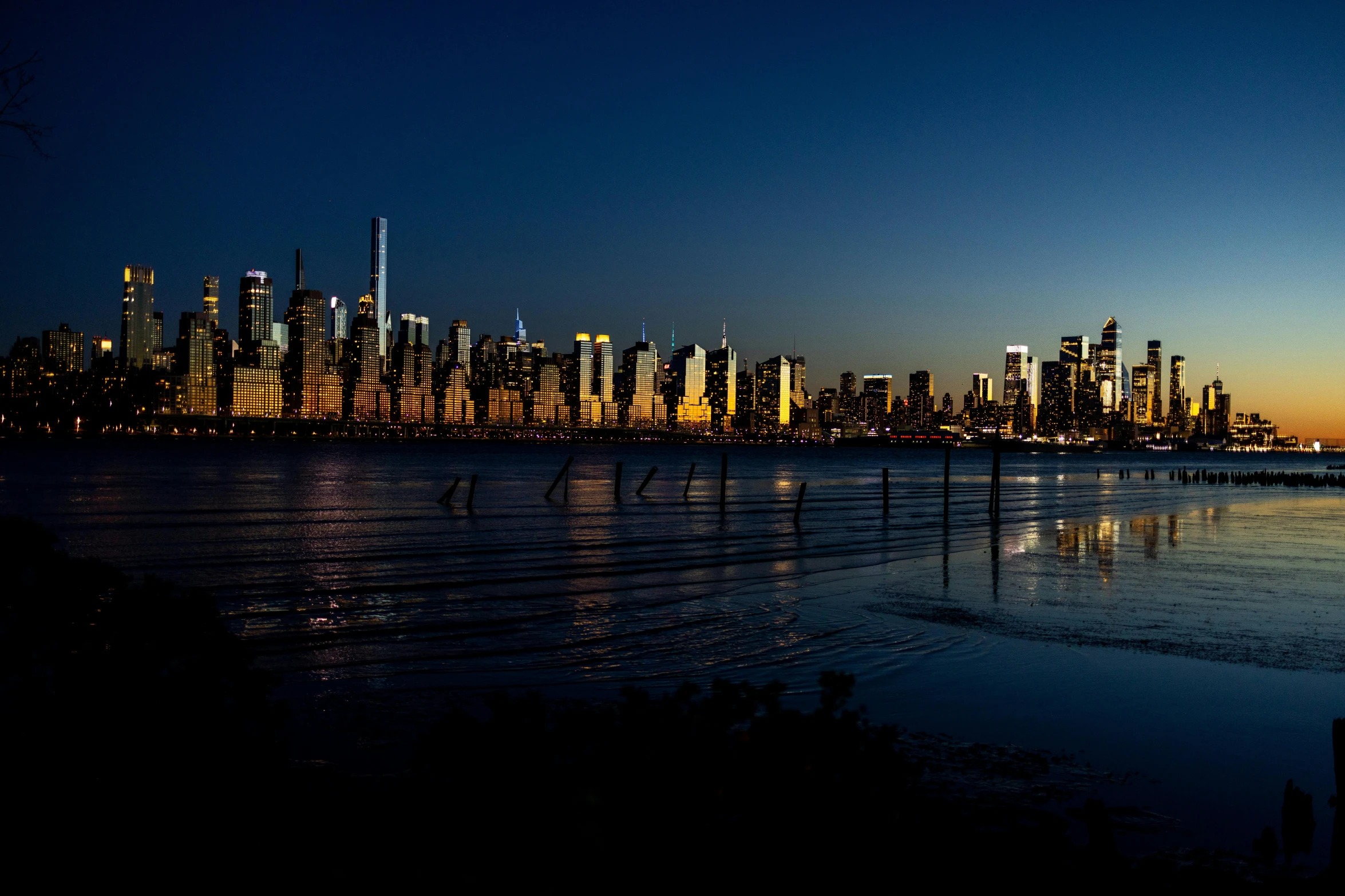 the city sits behind a small body of water at night