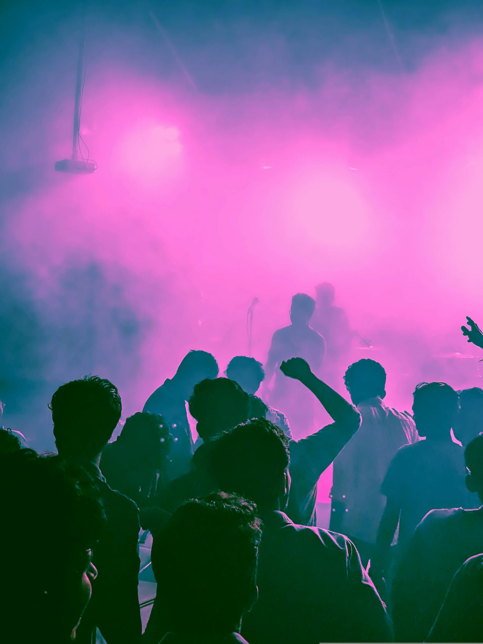 people standing around a dark and foggy stage