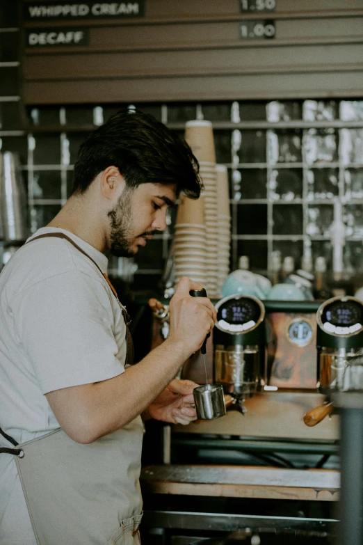 a man wearing an apron works on a machine