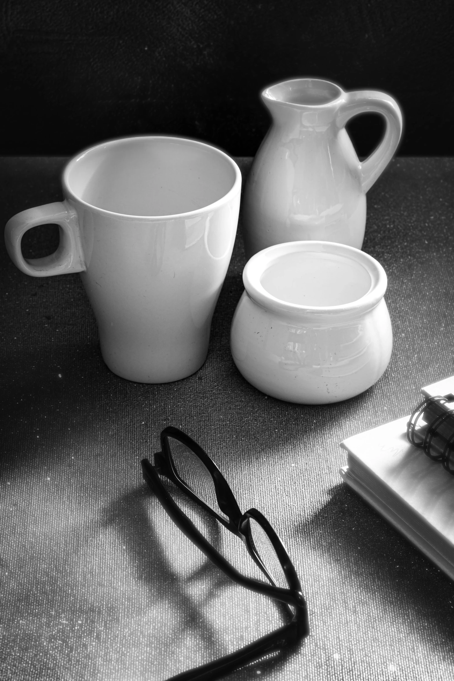 a table with three pitchers, one bowl and some other items