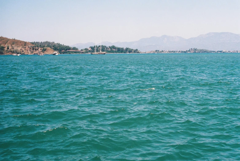 a boat on the water with mountains in the background