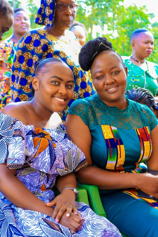 a group of women in african clothing sitting next to each other