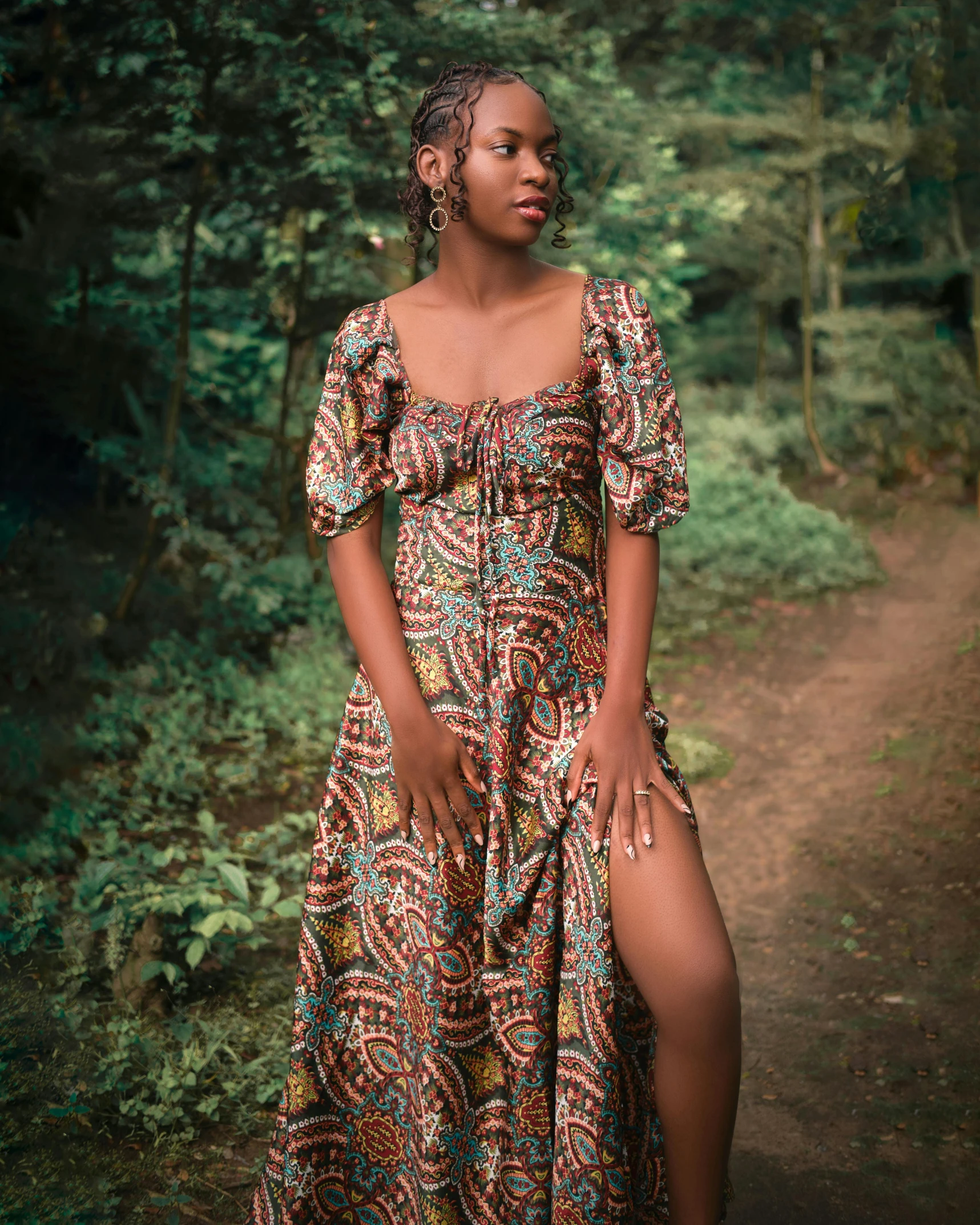 a girl wearing a multicolored dress in a forest