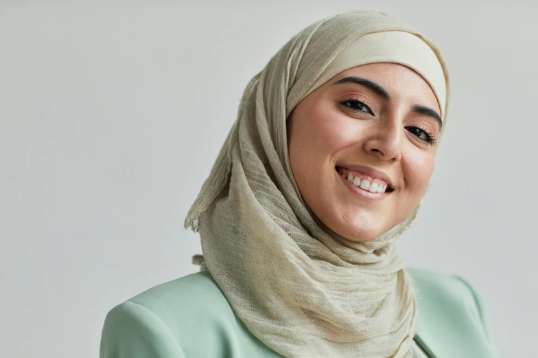 a woman wearing a white head scarf smiling