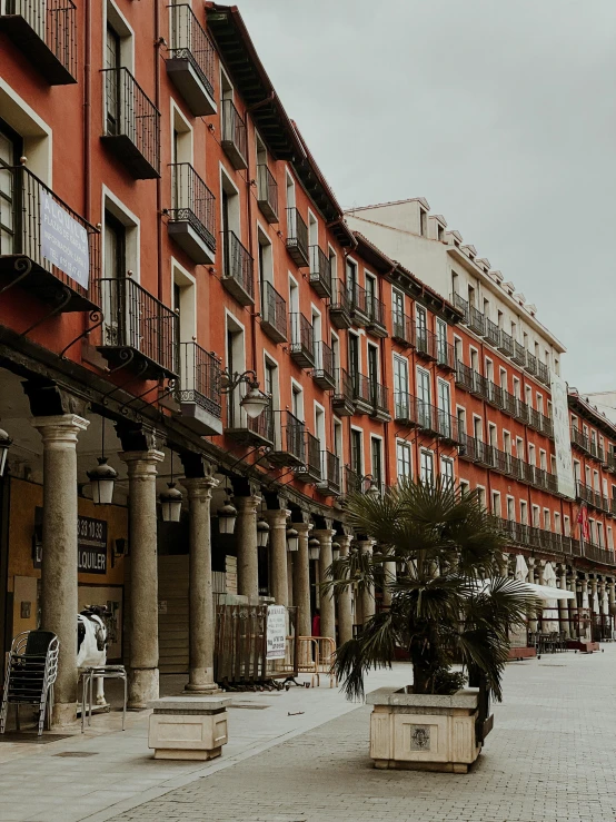 several people on a sidewalk lined with rows of apartment buildings