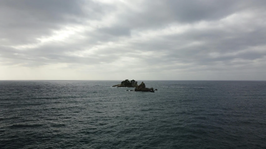 a view of the ocean with a small island in the middle