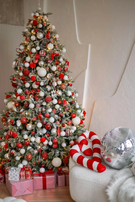 a red and white christmas tree with decorations