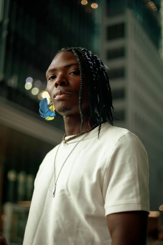 a black man with dreadlocks standing and looking at soing