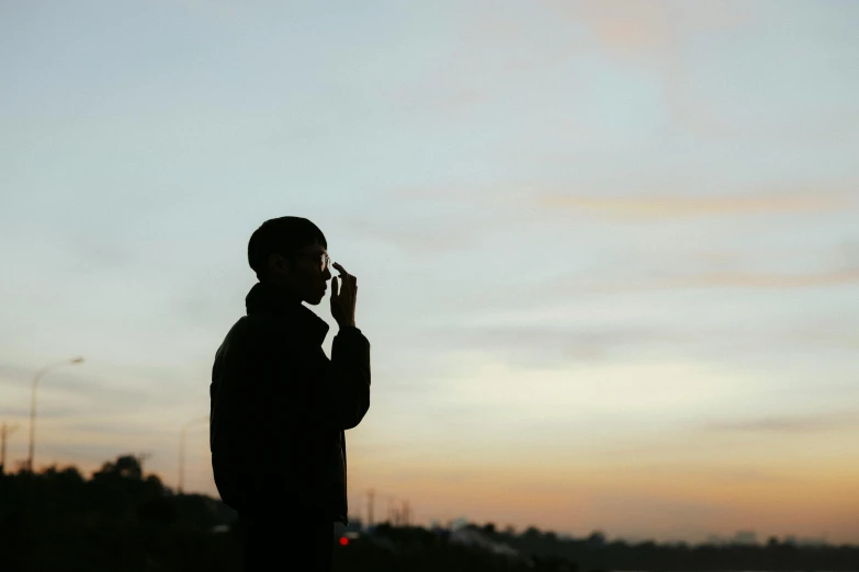 person standing on the sidewalk taking a picture with his cell phone