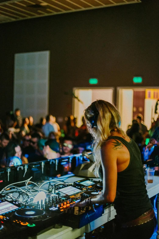 woman at dj booth listening to various tracks