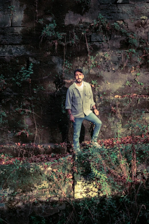 a man stands on top of a wooden log with greenery surrounding it