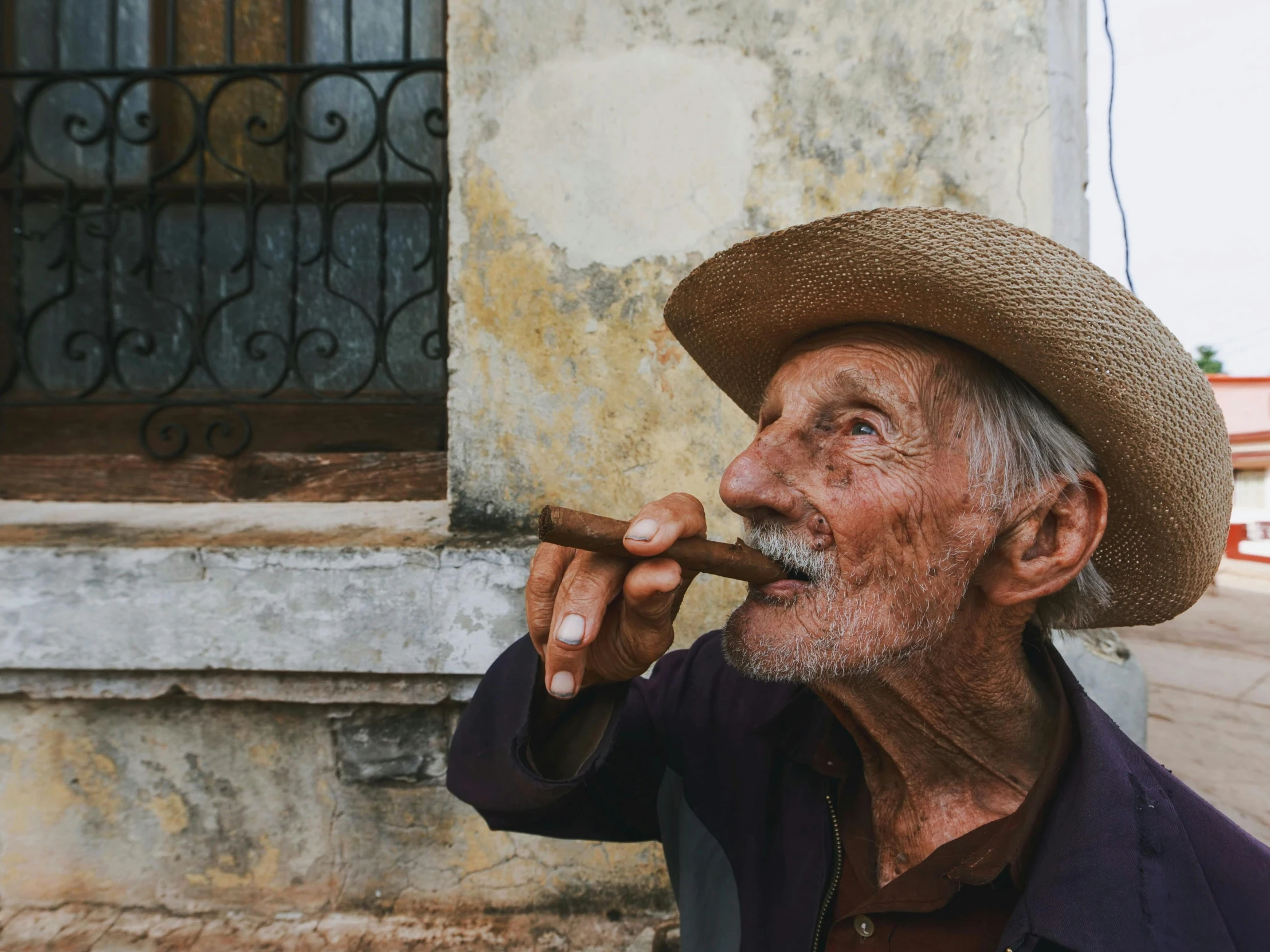 the old man is smoking soing outside by himself