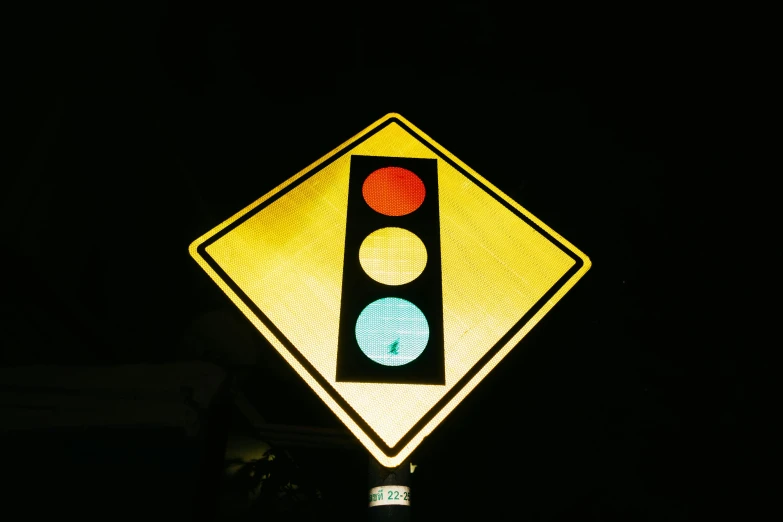 a traffic light sitting above a street sign at night