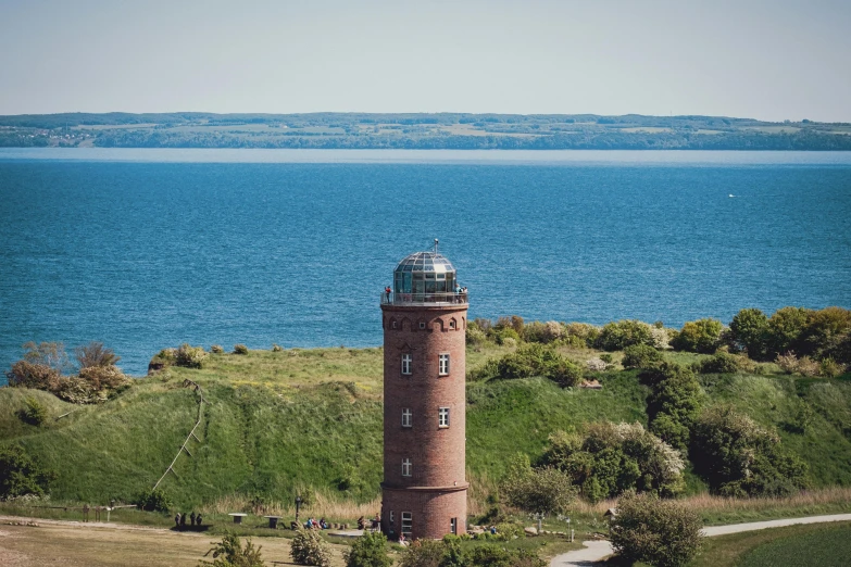 a view of the top of a tower in a field and a body of water in the distance