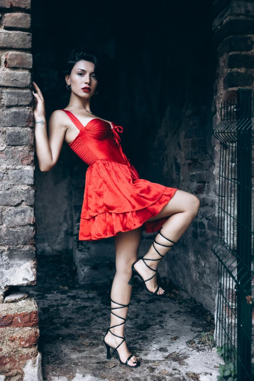 a beautiful young woman in red posing in a doorway