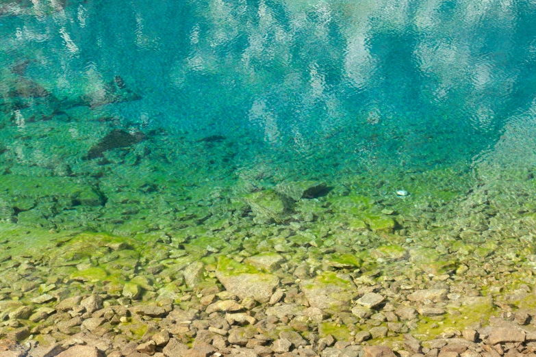 the blue and green water is above the stones