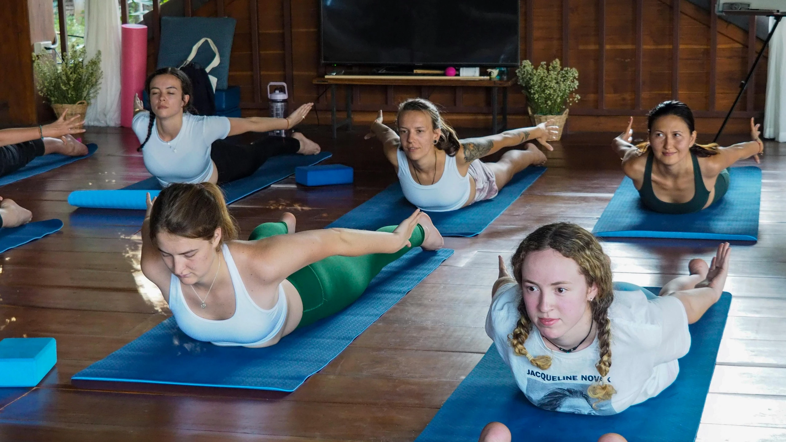 women doing yoga exercises in a class together