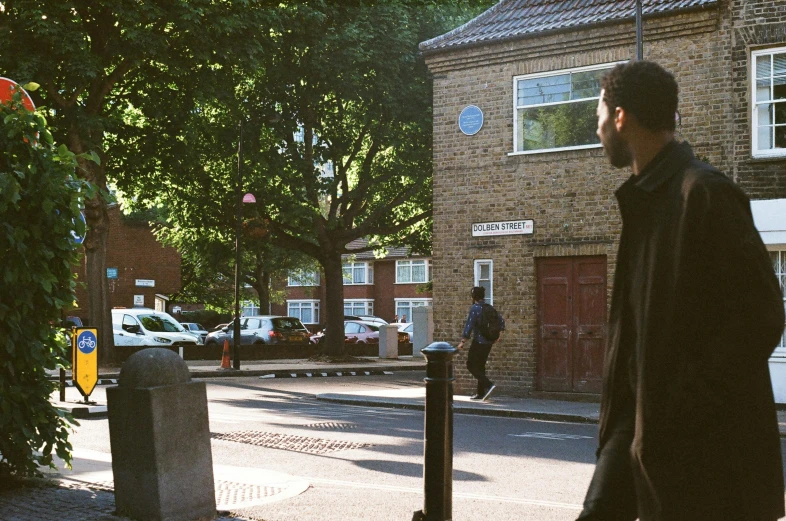 a man standing on a sidewalk next to a building