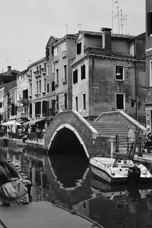 boats docked at a river side next to buildings