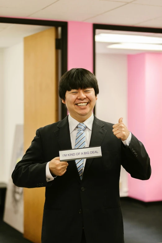 a man in a suit is smiling holding a piece of paper