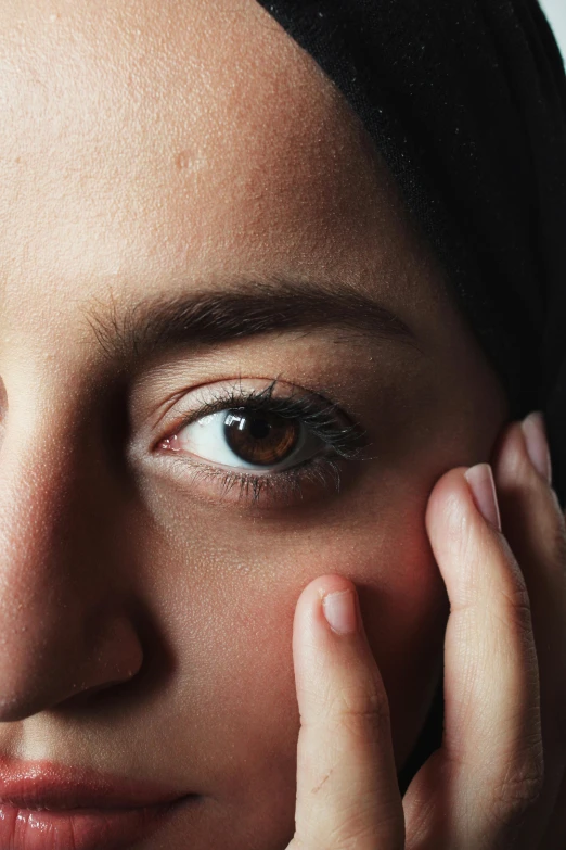 a close up s of a womans eyes with a ring on her left finger