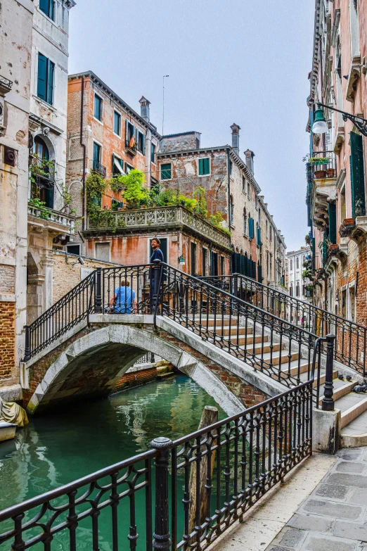 a bridge in venice that has a few people on it