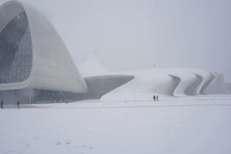 people stand outside a building in a large snow storm