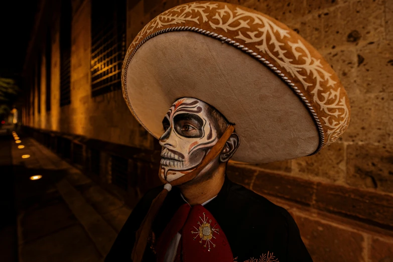 a man wearing sombrero with a skull face paint
