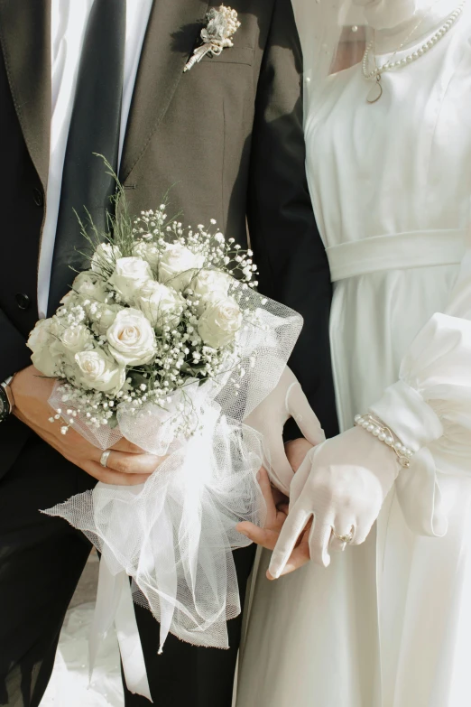 the man and woman are wearing gloves while holding flowers