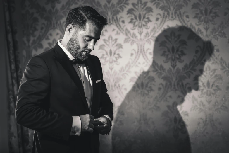 black and white pograph of man in suit looking at his watch