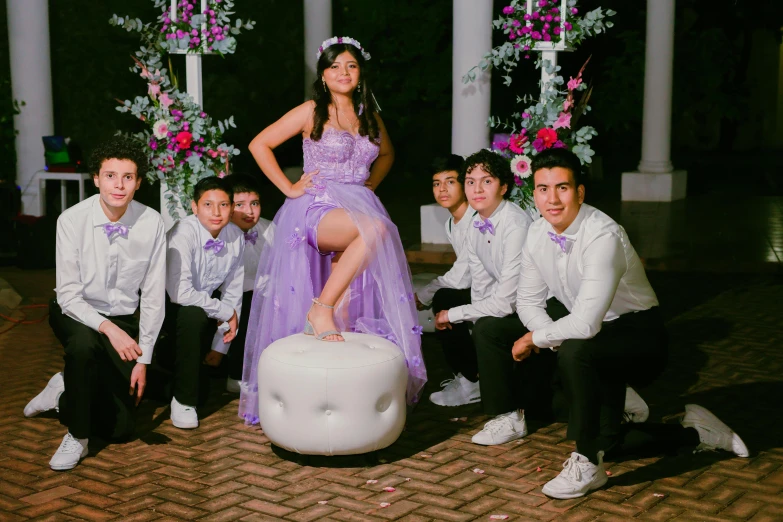 a woman in a purple dress poses with her crew