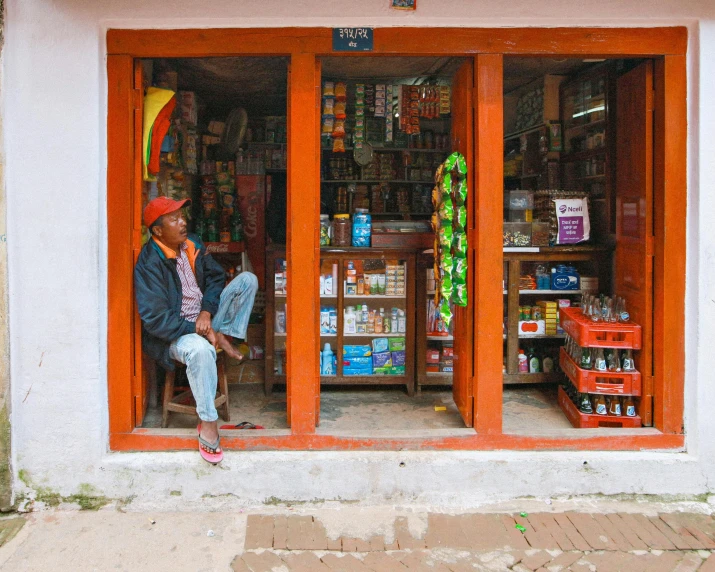 a man sitting on the ledge in a store