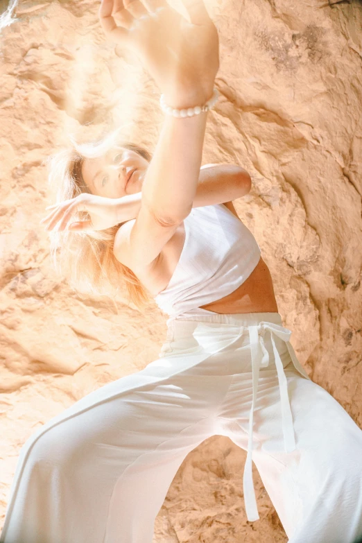 a woman in white pants is in sand