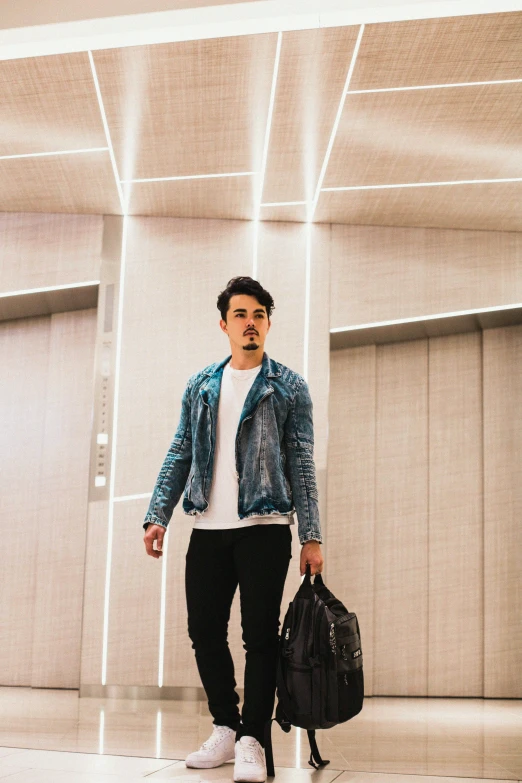 a man walking through a large hallway with white walls