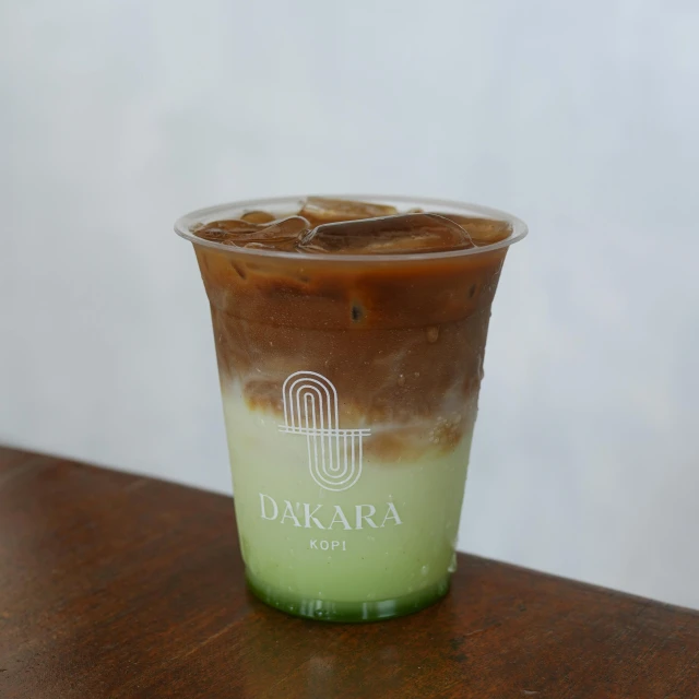 a beverage cup with dark liquid, ice and other items