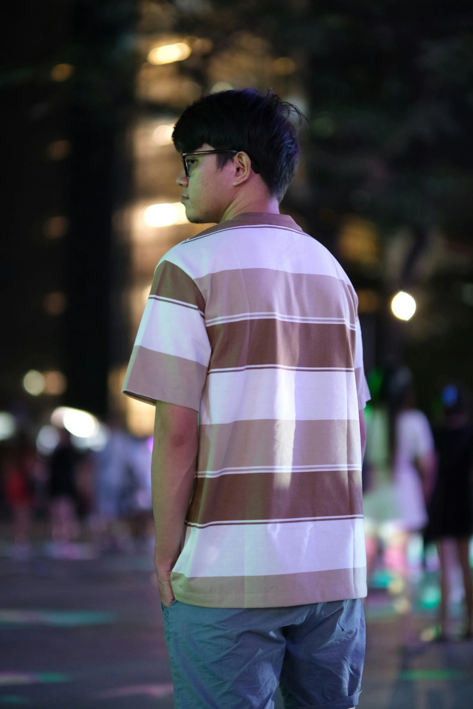 a guy standing alone in the street at night