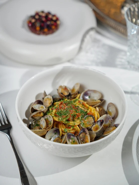 a white bowl full of food sitting on top of a table