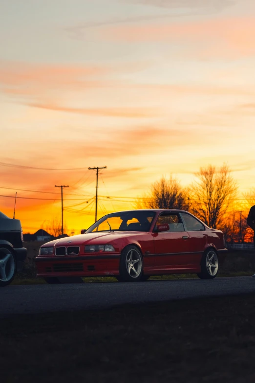 a red mustang parked next to another one in a field