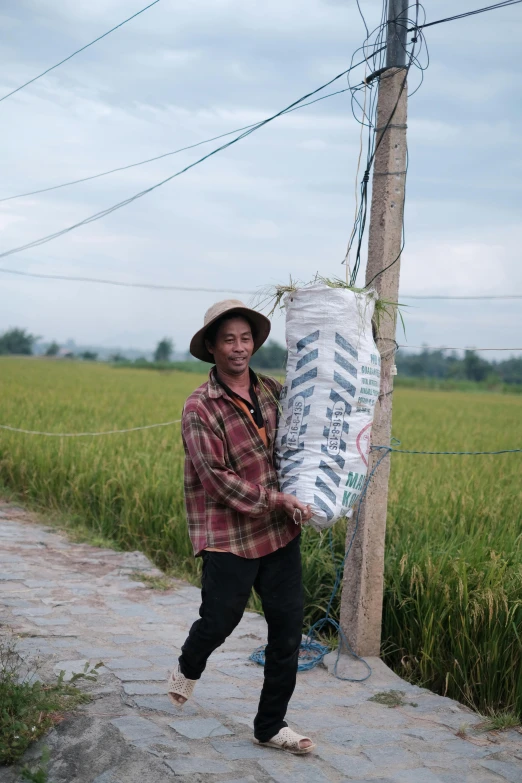 the man carries newspapers up the side of the road