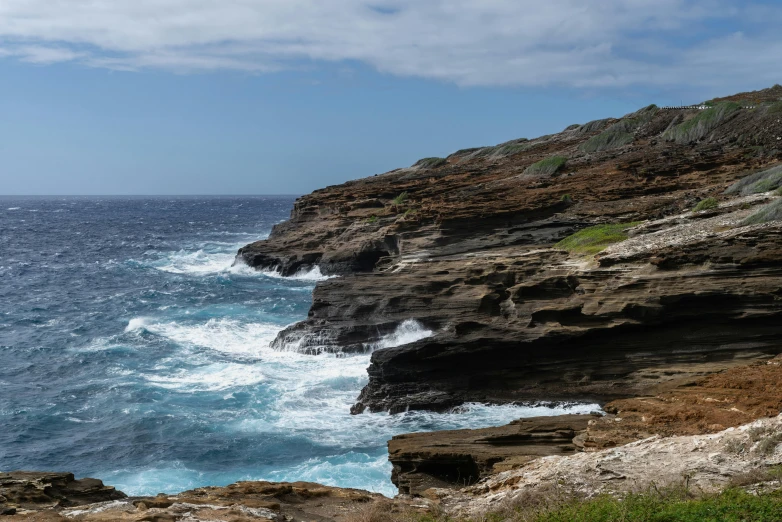 a sea side cliff is seen on a cloudy day