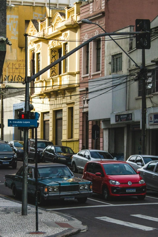 a traffic light above a street full of parked cars