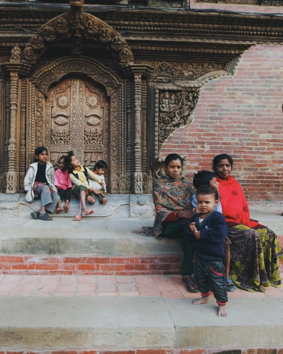 a group of people are sitting outside and a building