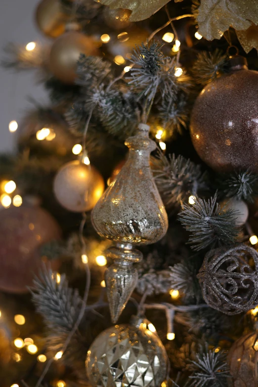 this christmas tree has several silver and gold ornaments