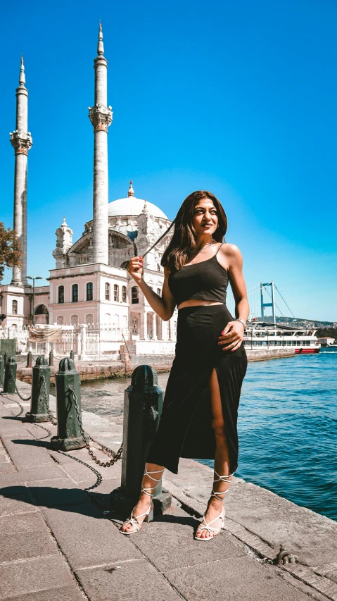 woman posing for a pograph on a pier near a body of water