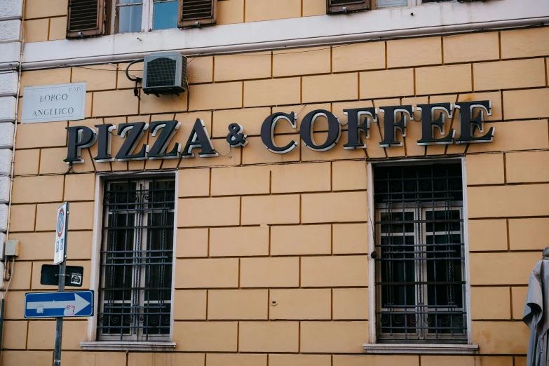 a yellow wall that says pizza & coffee