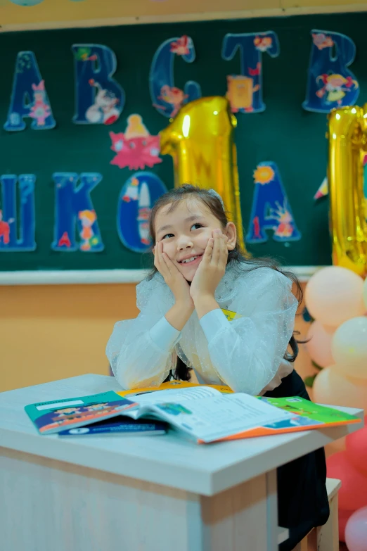 a girl wearing white in front of a desk