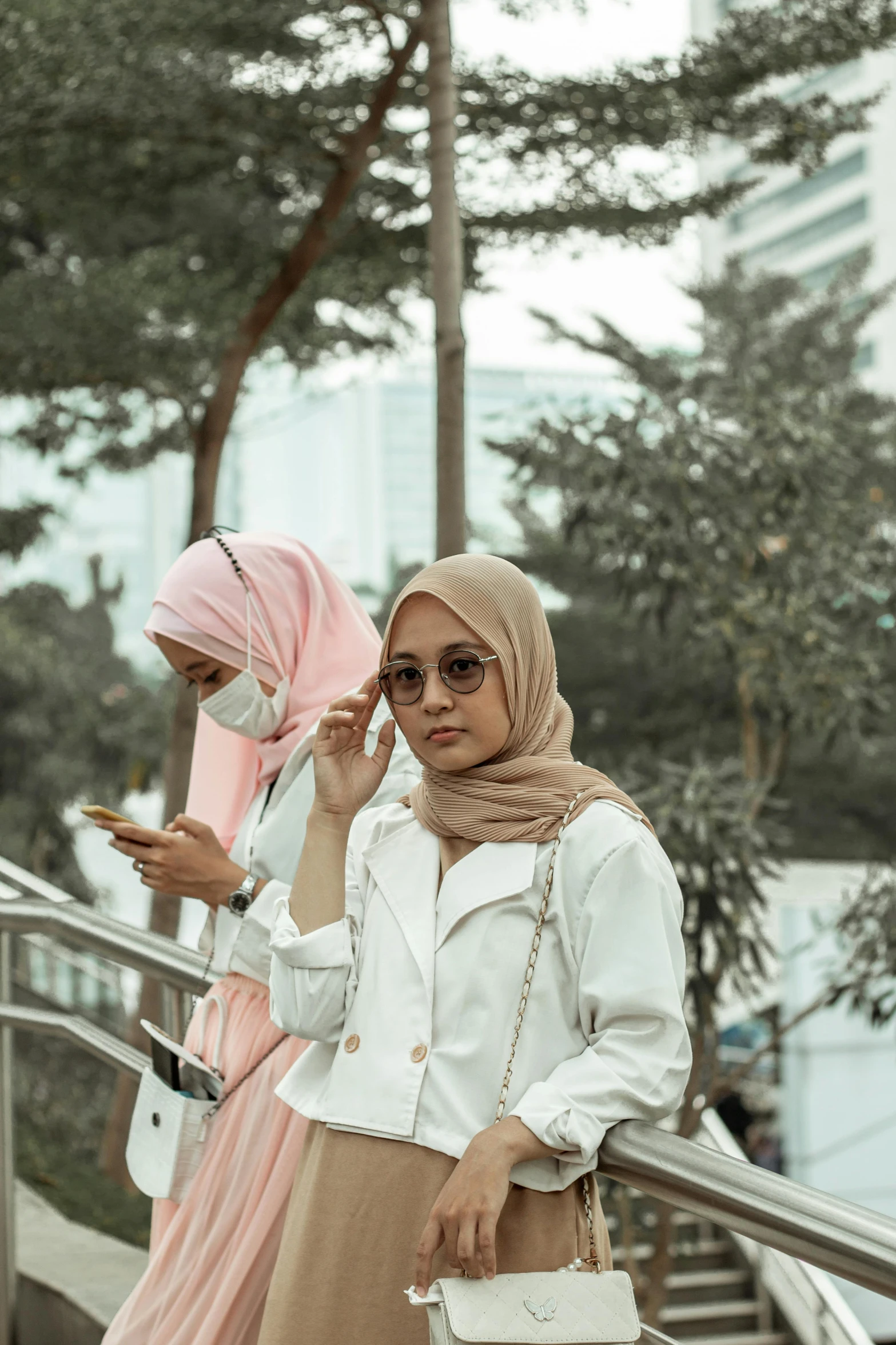 a woman walking down some steps while wearing a white coat and a pink scarf