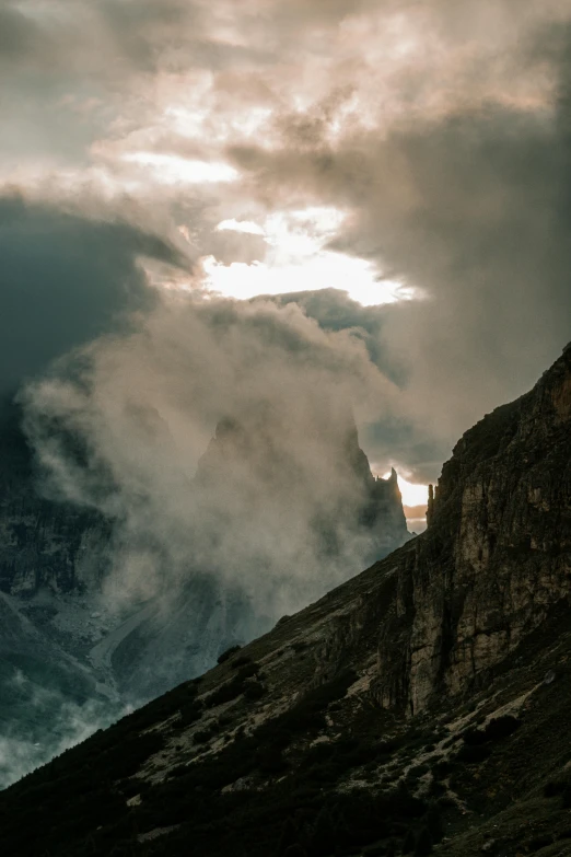 some dark clouds are blowing over the mountains