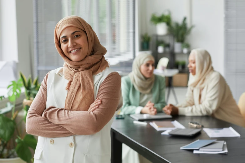 a group of women sitting at a desk smiling